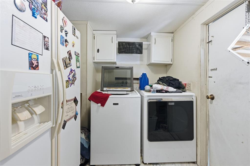 13050 Sun Road Brooksville, FL 34613 - Photo 4 of 47 a view of washer and dryer with kitchen in the background