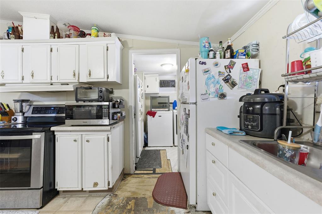 13050 Sun Road Brooksville, FL 34613 - Photo 5 of 47 a kitchen with refrigerator and cabinets