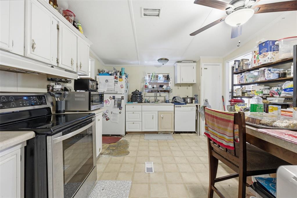 13050 Sun Road Brooksville, FL 34613 - Photo 9 of 47 a kitchen with a stove cabinets and white appliances