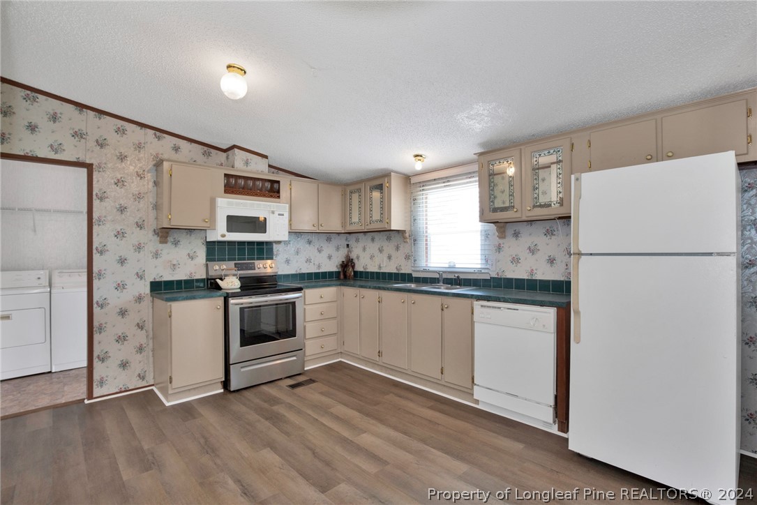 2147 Bainbridge Road Stedman, NC 28391 - Photo 9 of 42 a kitchen with a refrigerator and a stove top oven