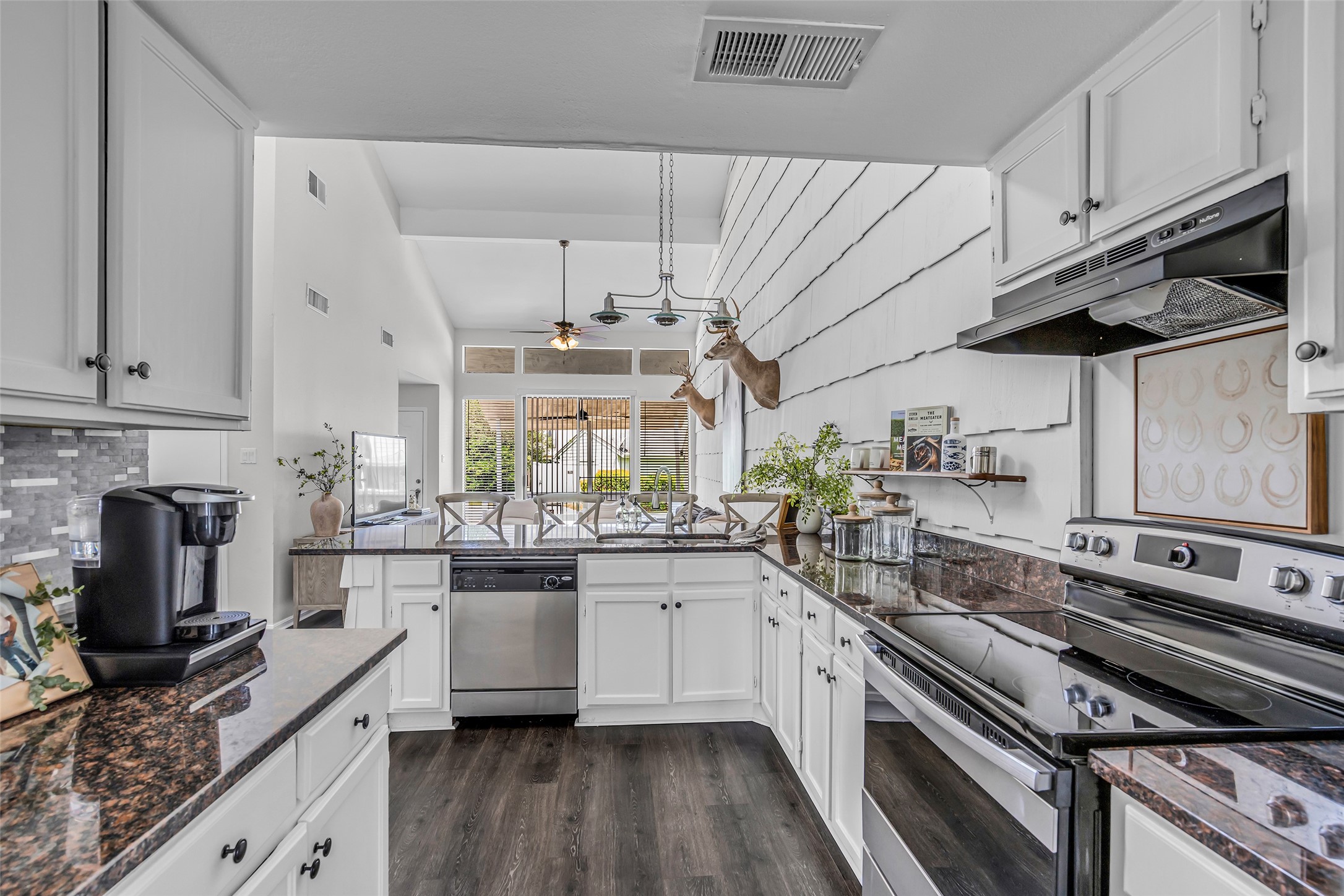 62 April Point Drive North Conroe, TX 77356 - Photo 12 of 25 a kitchen with stainless steel appliances a stove a sink and white cabinets