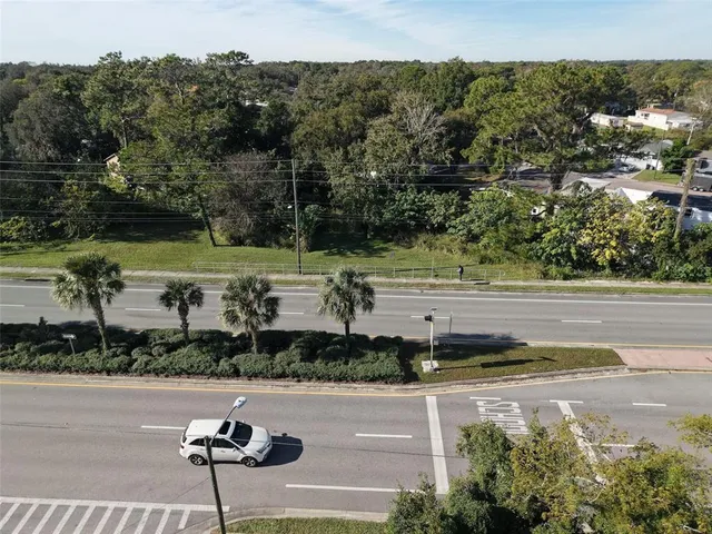 a view of a street with a yard and a large parking space