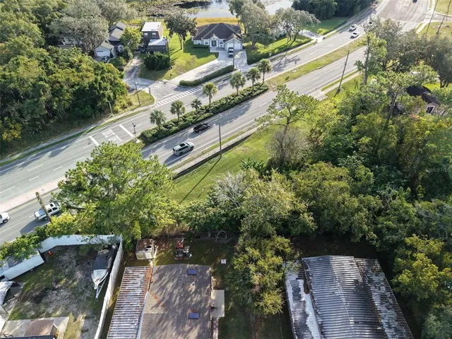 an aerial view of residential houses with outdoor space and trees