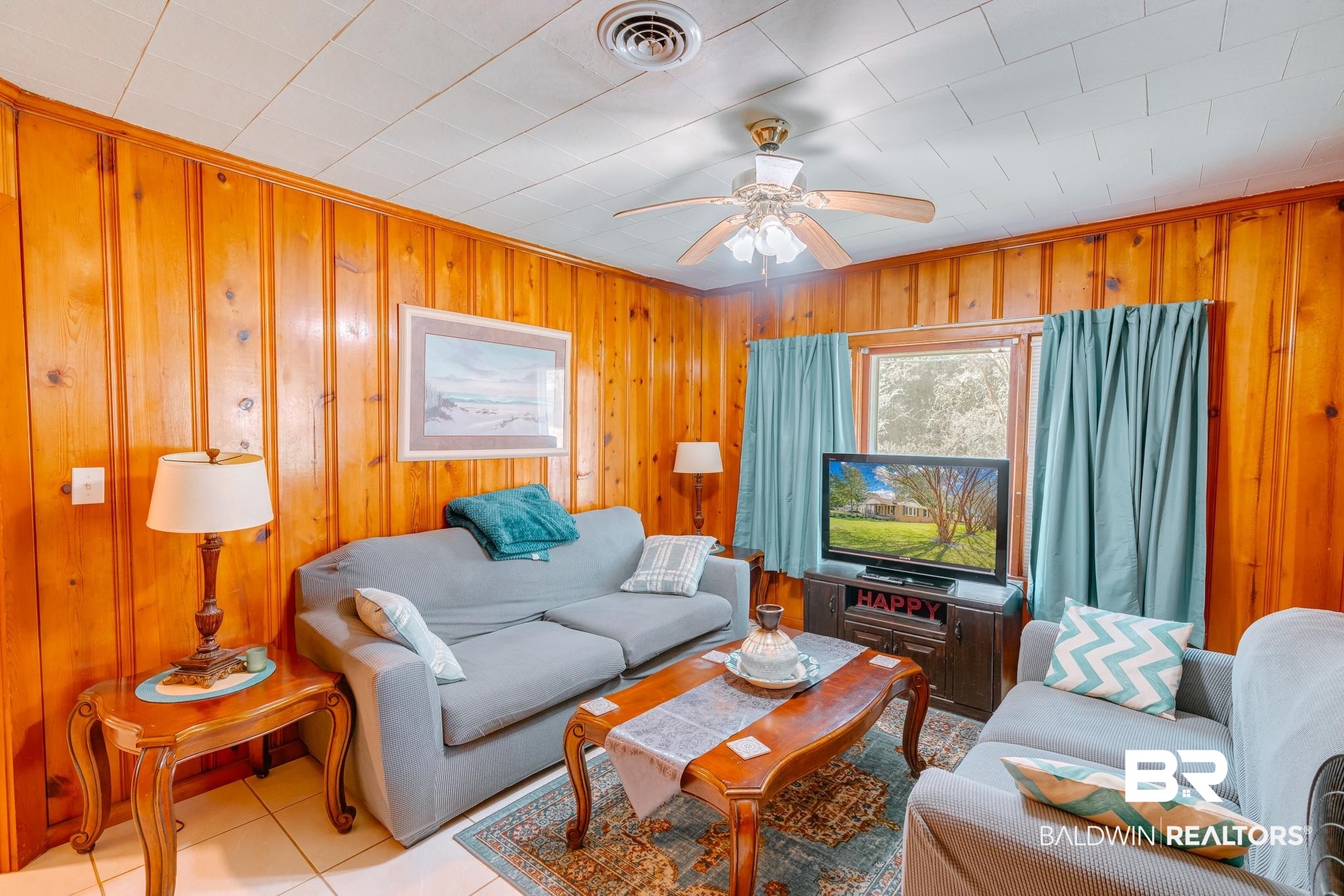 315 Fourth Avenue Chickasaw, AL 36611 - Photo 17 of 28 Living area featuring light tile patterned floors, visible vents, a ceiling fan, and wooden walls
