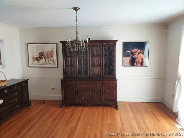 a view of a bedroom with wooden floor and dresser