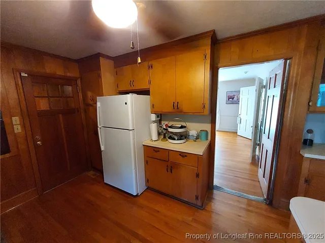 a white refrigerator freezer and a stove sitting inside of a kitchen