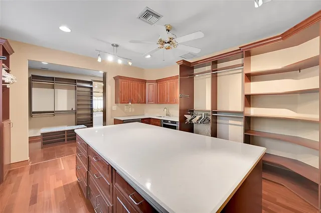 a bedroom with a large bed and a chandelier fan