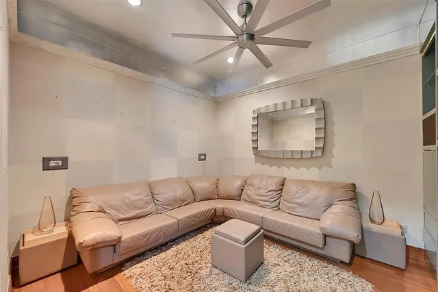 a living room with stainless steel appliances furniture a rug and a kitchen view