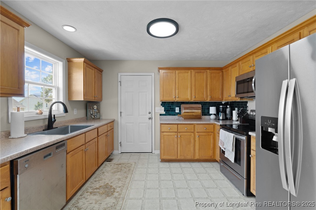 106 Polk Street Spring Lake, NC 28390 - Photo 15 of 47 a kitchen with stainless steel appliances granite countertop a stove a sink dishwasher a refrigerator and a microwave