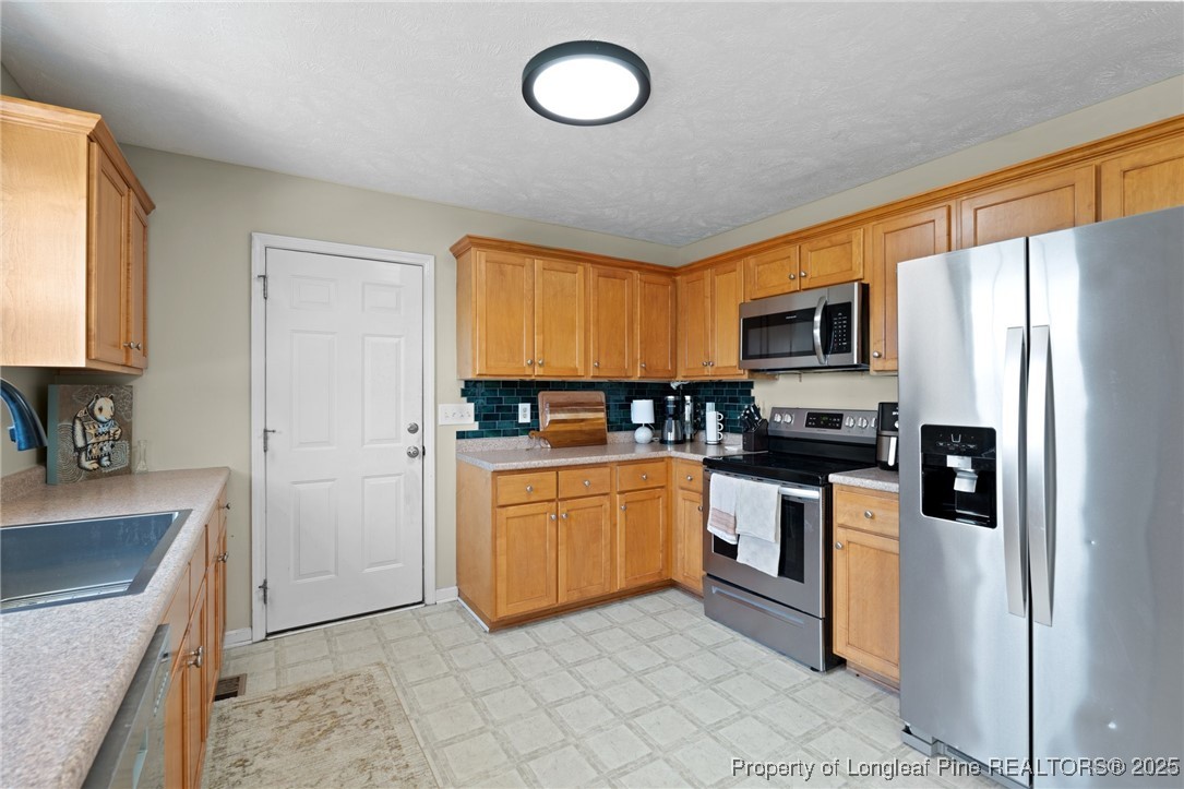 106 Polk Street Spring Lake, NC 28390 - Photo 16 of 47 a kitchen with stainless steel appliances granite countertop a refrigerator stove top oven and sink