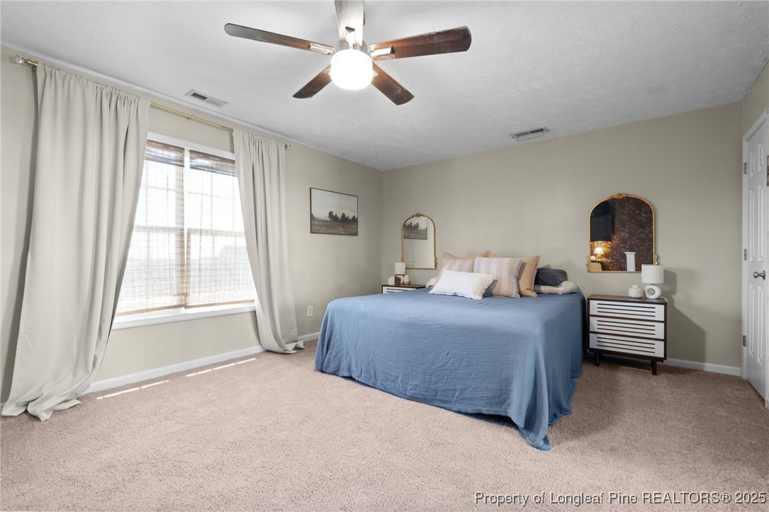 106 Polk Street Spring Lake, NC 28390 - Photo 20 of 47 a bedroom with a bed and a chandelier