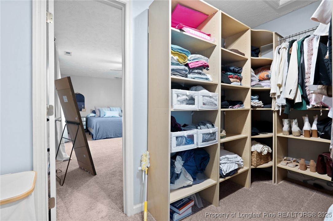 106 Polk Street Spring Lake, NC 28390 - Photo 23 of 47 a view of walk in closet with clothes and shoes