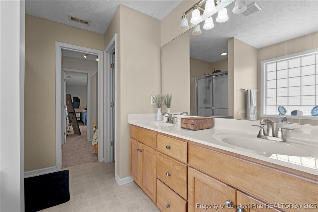 106 Polk Street Spring Lake, NC 28390 - Photo 24 of 47 a en suite bathroom with a double vanity sink and a mirror