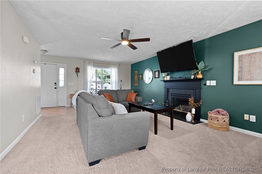 106 Polk Street Spring Lake, NC 28390 - Photo 10 of 47 a living room with furniture a fireplace and a flat screen tv
