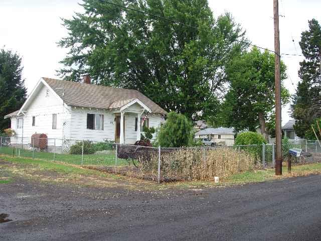 a view of a white house with a yard and garage