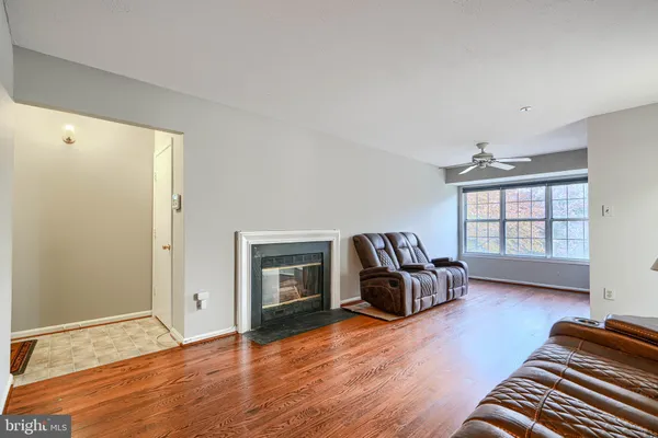 a living room with furniture hardwood floor and a window