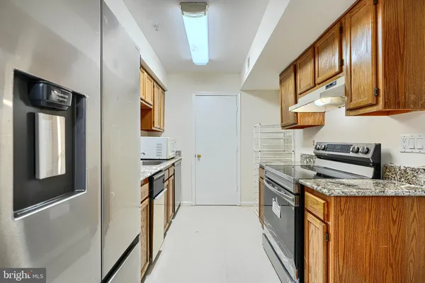 a kitchen with stainless steel appliances granite countertop a stove a sink and a refrigerator