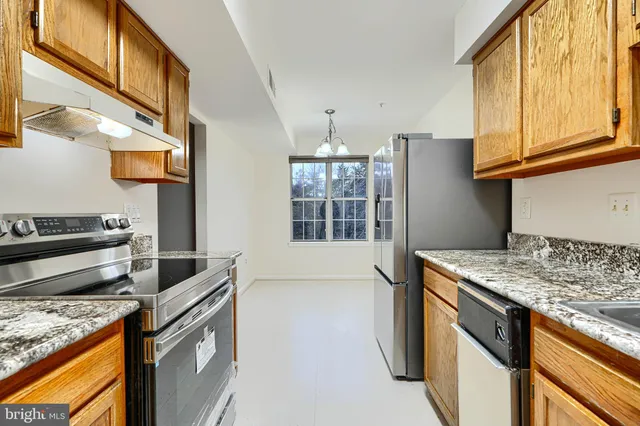 a kitchen that has a sink a stove and a microwave