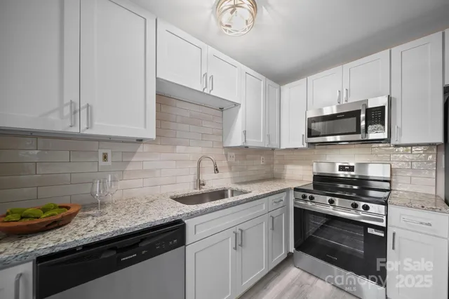 a kitchen with granite countertop a sink a stove and cabinets
