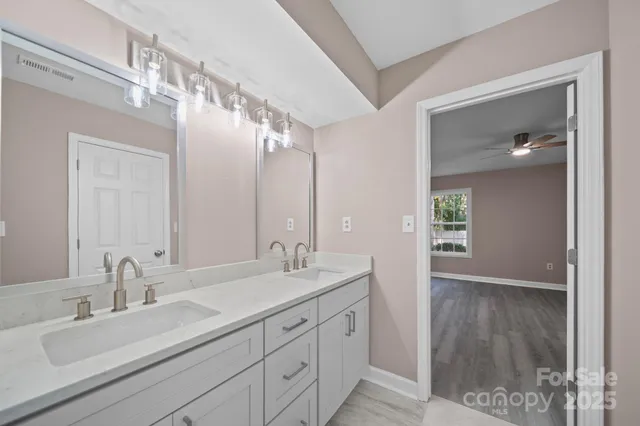 a bathroom with a double vanity sink mirror and shower