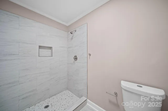 a bathroom with a toilet and a shower