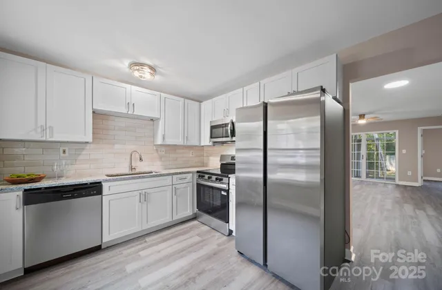 a kitchen with a refrigerator sink and cabinets
