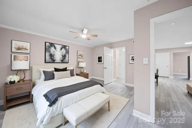 a spacious bedroom with a bed and a painting on the wall