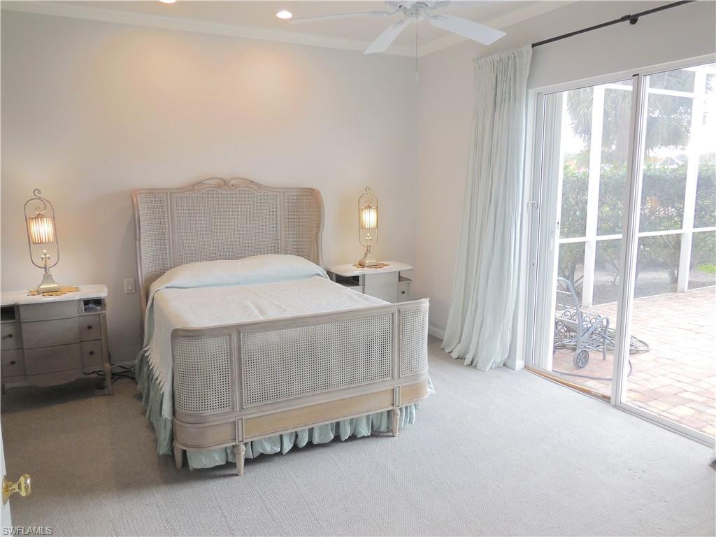 5163 Inagua Way Naples, FL 34119 - Photo 30 of 50 a bedroom with a bed and a night stand