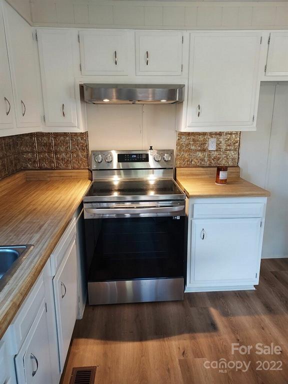 116 Circle Drive Fallston, NC 28090 - Photo 9 of 23 a kitchen with granite countertop a stove and white cabinets