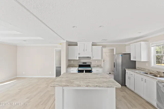 a kitchen with stainless steel appliances a stove refrigerator sink and cabinets