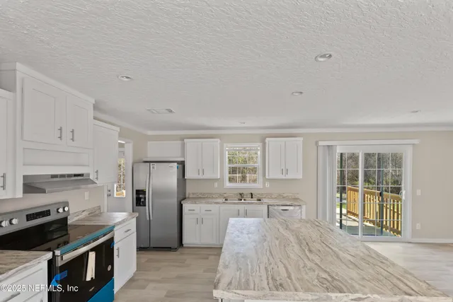 a kitchen with stainless steel appliances granite countertop a refrigerator and a stove
