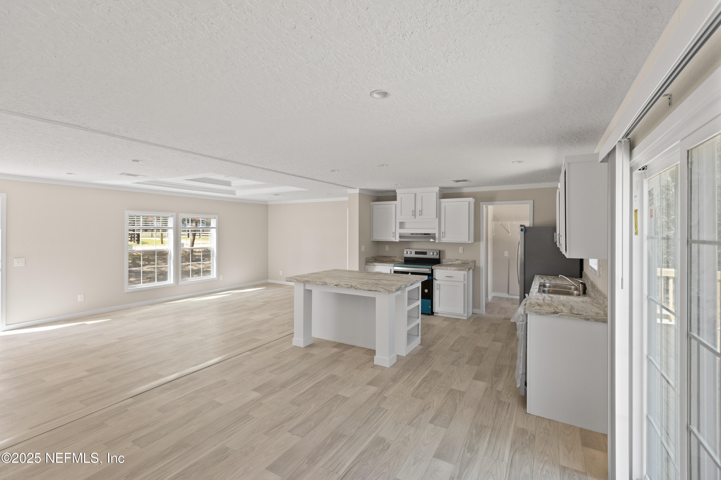 6012 Indian Trail Keystone Heights, FL 32656 - Photo 31 of 61 a large white kitchen with cabinets and wooden floor