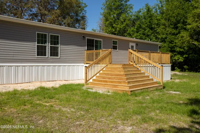 a view of a house with backyard and trees