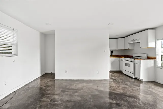 a view of kitchen with granite countertop cabinets and white appliances