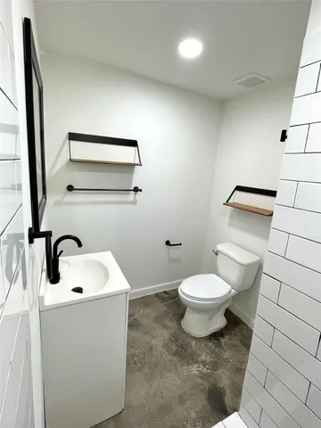 a bathroom with a toilet sink and mirror