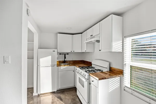 a kitchen with cabinets appliances a sink and a window