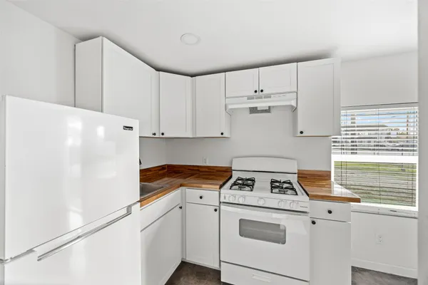 a kitchen with cabinets appliances a sink and a window