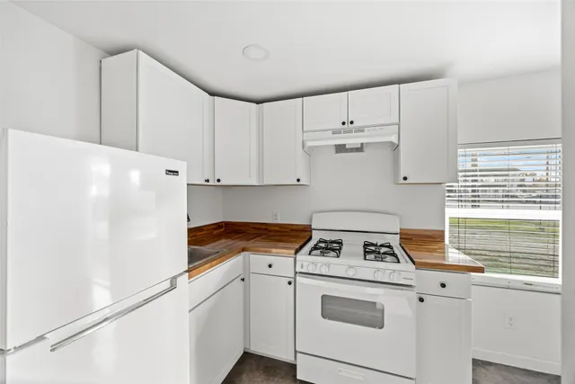 a kitchen with cabinets appliances a sink and a window
