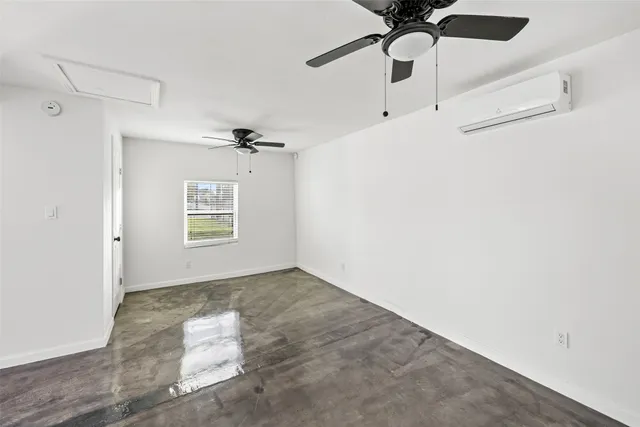 an empty room with a window and a fan
