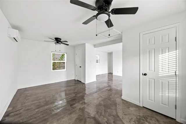 wooden floor in an empty room with a chandelier fan