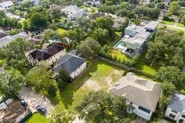 an aerial view of residential houses with outdoor space and trees all around