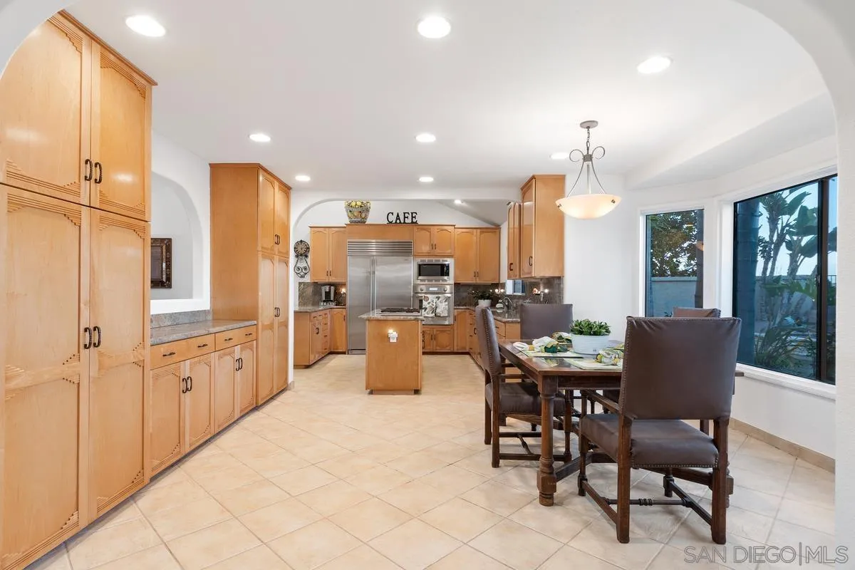 445 Via Savoy Encinitas, CA 92024 - Photo 11 of 39 a kitchen with stainless steel appliances kitchen island granite countertop a sink and cabinets