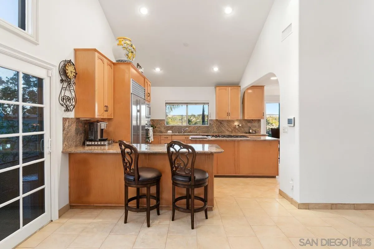 445 Via Savoy Encinitas, CA 92024 - Photo 13 of 39 a kitchen with stainless steel appliances a refrigerator and wooden cabinets