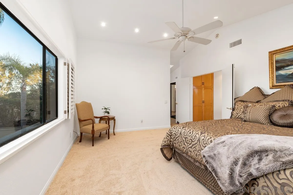445 Via Savoy Encinitas, CA 92024 - Photo 17 of 39 a bedroom with a bed and large windows