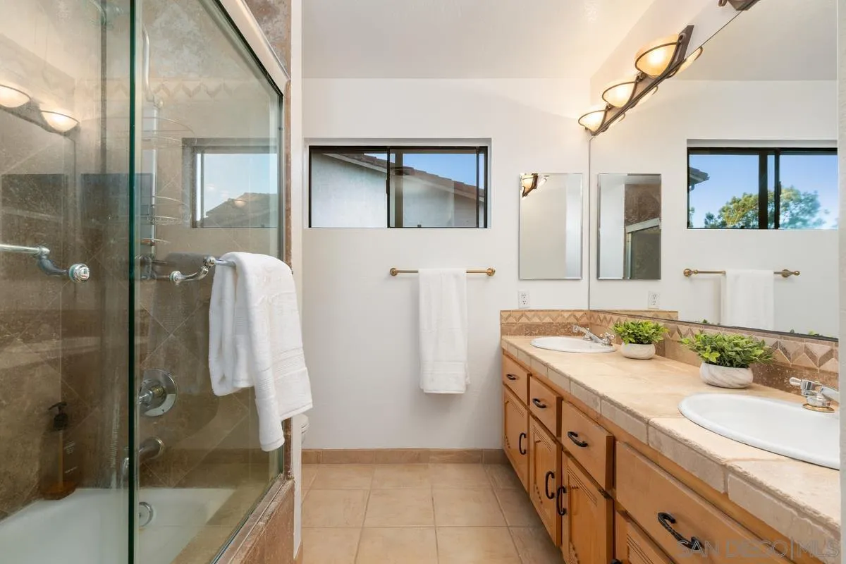 445 Via Savoy Encinitas, CA 92024 - Photo 22 of 39 a bathroom with a double vanity sink a mirror and a shower