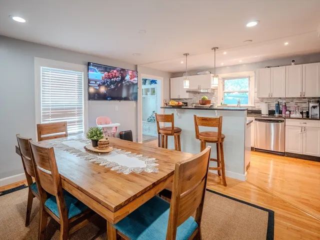 a dining room with furniture wooden floor dining table and kitchen view