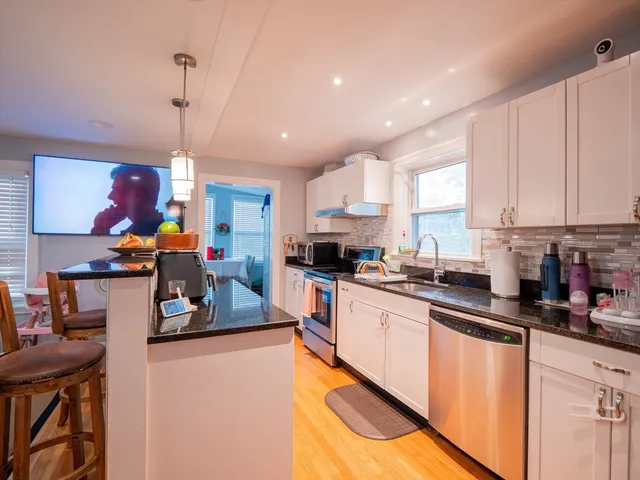a kitchen that has a lot of cabinets a sink and appliances