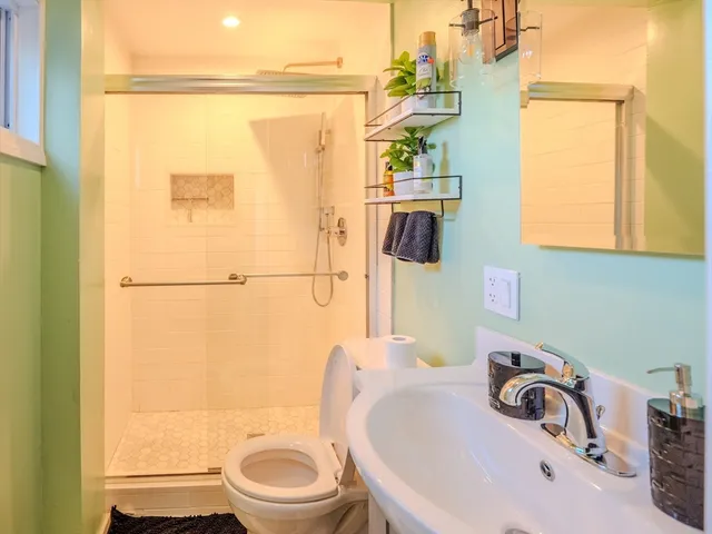 a bathroom with a sink a toilet and a mirror