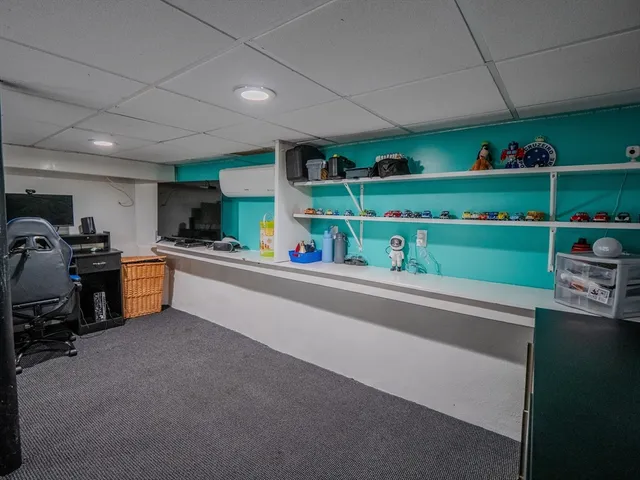 a living room with chairs and kitchen view