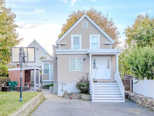 a view of a white house with a yard and plants